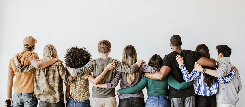 A group of diverse people with their hands around each other
