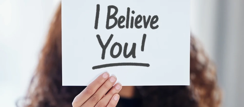 Person holding a sign that says I Believe You!